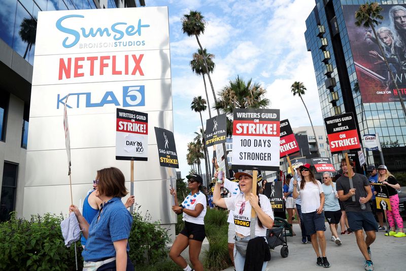 © Reuters. SAG-AFTRA actors and Writers Guild of America (WGA) writers walk the picket line during their ongoing strike, outside Netflix offices in Los Angeles, California, U.S., August 9, 2023. REUTERS/Mario Anzuoni