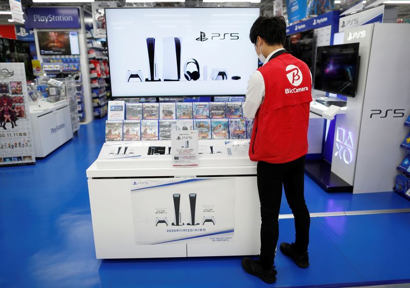 &copy; Reuters. FILE PHOTO-An employee of the consumer electronics retailer chain Bic Camera works at the promotion display for the Sony PlayStation 5 game console and its gaming softwares in Tokyo, Japan, November 10, 2020. Picture taken November 10, 2020.  REUTERS/Isse