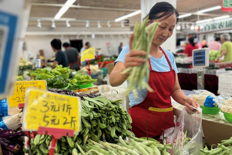 &copy; Reuters. A vegetable vendor attends to customers at a wet market in Beijing, China August 10, 2023. REUTERS/Yew Lun Tian