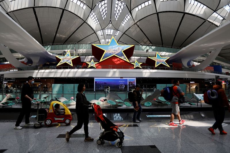 &copy; Reuters. Photo d'archives des  voyageurs qui passent devant une installation en forme de cinq étoiles, à l'aéroport international de Pékin Daxing à Pékin. /Photo prise le 24 avril 2023 à Pékin, Chine/REUTERS/Tingshu Wang