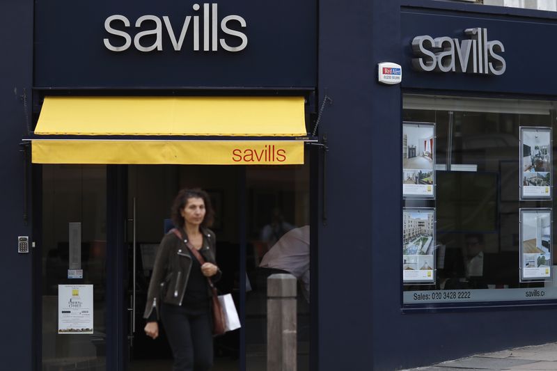 &copy; Reuters. FILE PHOTO: A woman walks past a Savills estate agent office in south London, Britain September 20, 2016.  REUTERS/Stefan Wermuth/File Photo