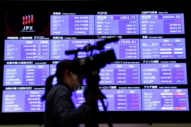 &copy; Reuters. FOTO DE ARCHIVO: Una persona de los medios de comunicación frente al tablero de cotización de acciones durante una ceremonia que marca el final de las operaciones de 2022 en la Bolsa de Tokio en Tokio, Japón. 30 de diciembre, 2022. REUTERS/Issei Kato/A