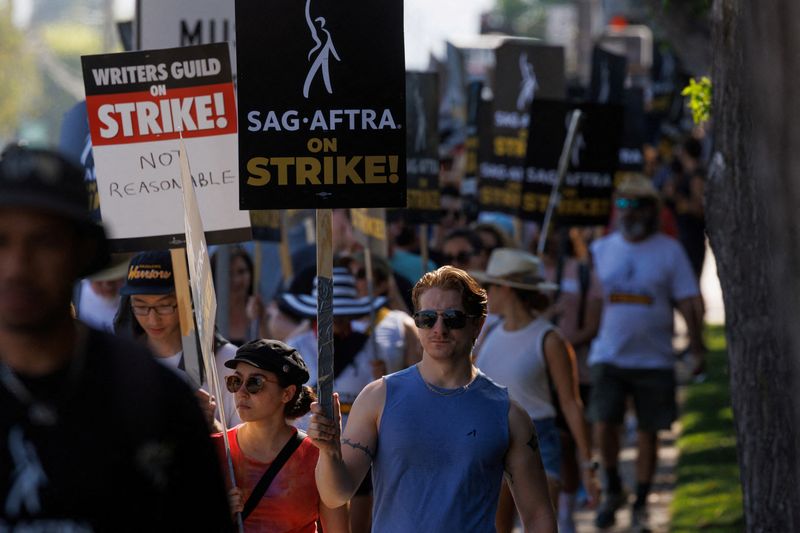 &copy; Reuters. FILE PHOTO: SAG-AFTRA actors and Writers Guild of America (WGA) writers walk the picket line outside Disney Studios in Burbank, California, U.S., July 25, 2023.   REUTERS/Mike Blake/File Photo