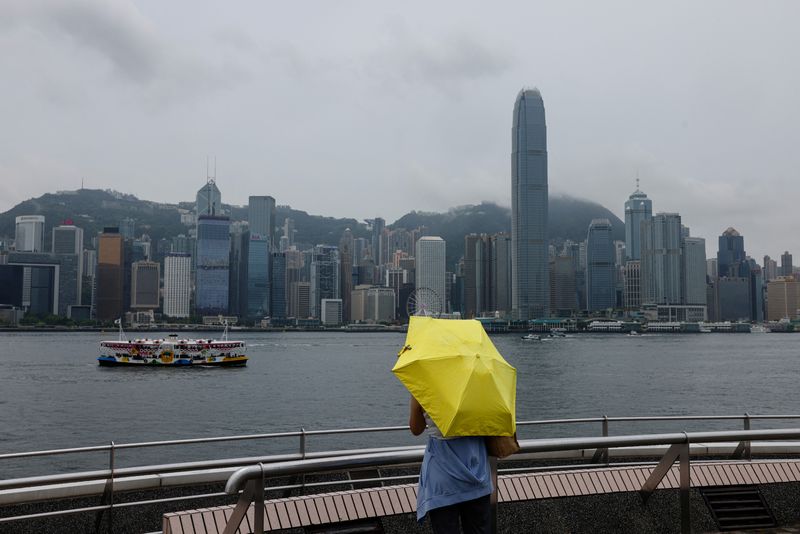 &copy; Reuters. A Chinese tourist takes photo in front of Victoria Harbour, with the backdrop of Central financial district, in Hong Kong, China, August 11, 2023. REUTERS/Tyrone Siu