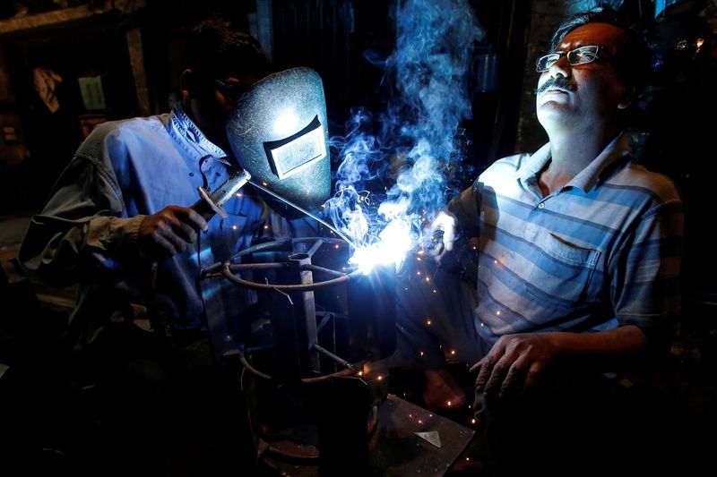 &copy; Reuters. FILE PHOTO: Workers weld an iron frame which will be used with a tractor for ploughing fields, at a workshop in an industrial area in Kolkata, India, February 12, 2019. REUTERS/Rupak De Chowdhuri/File Photo    