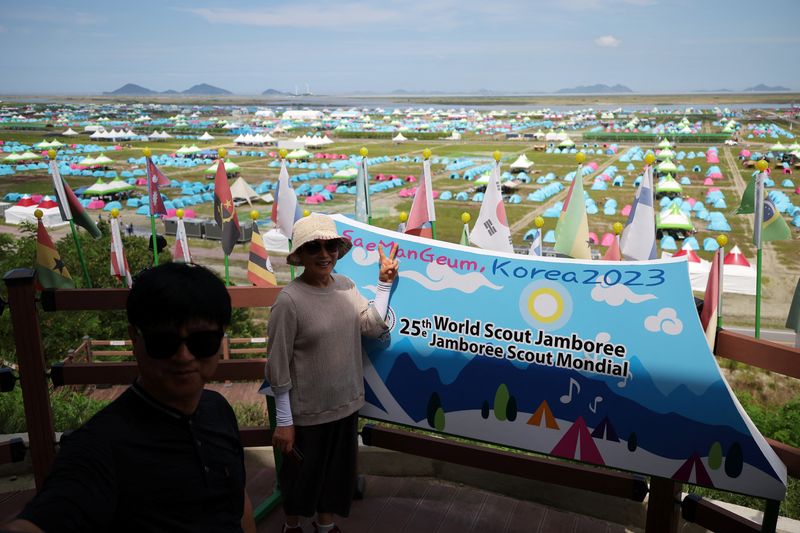 &copy; Reuters. Casal tira foto em frente a acampamento da 25ª edição do Jamboree Mundial de Escoteiros, na Coreia do Sul
4/8/2023 REUTERS/Kim Hong-Ji
