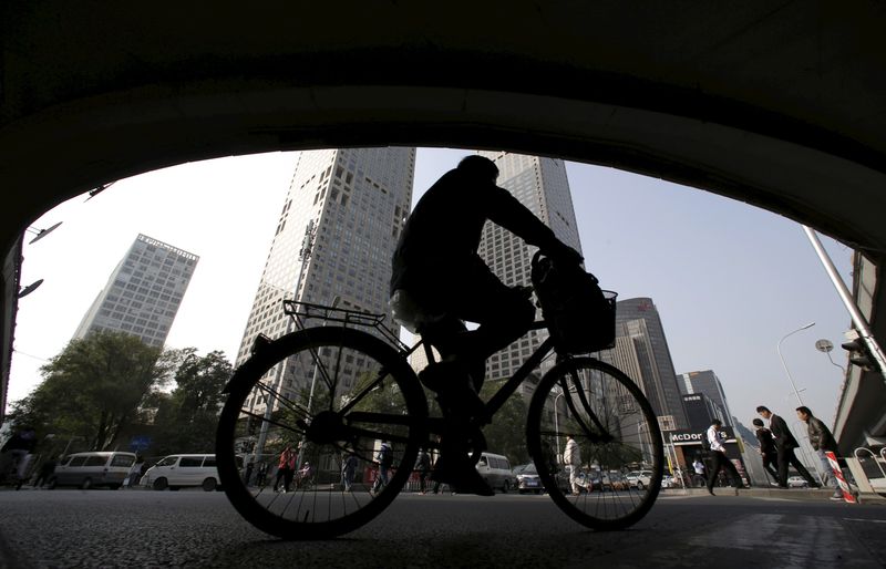 &copy; Reuters. FILE PHOTO: A man rides his bicycle across the street under the Guomao bridge at the Central Business District in Beijing, China, October 19, 2015.  REUTERS/Jason Lee/File Photo