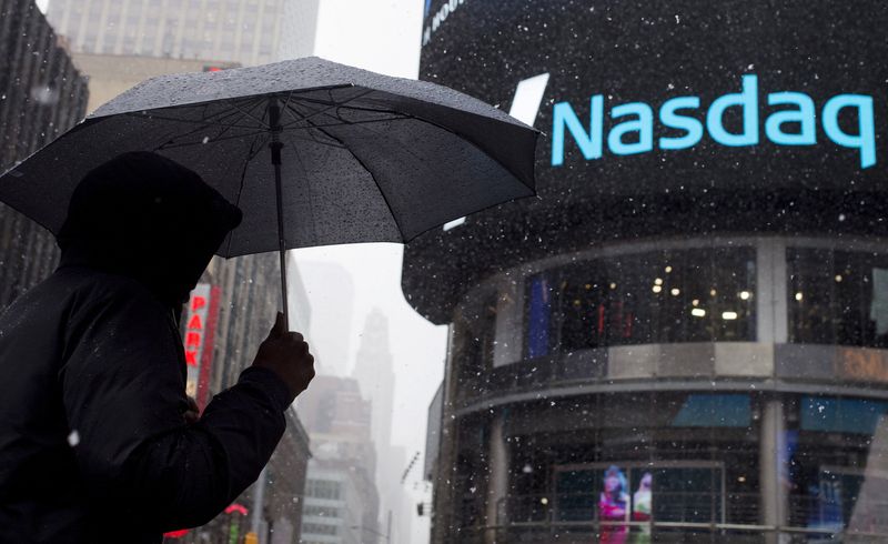 &copy; Reuters. FILE PHOTO: A man uses an umbrella to guard against snowfall as he walks past the Nasdaq MarketSite in Times Square, Midtown New York March 20, 2015.   REUTERS/Adrees Latif