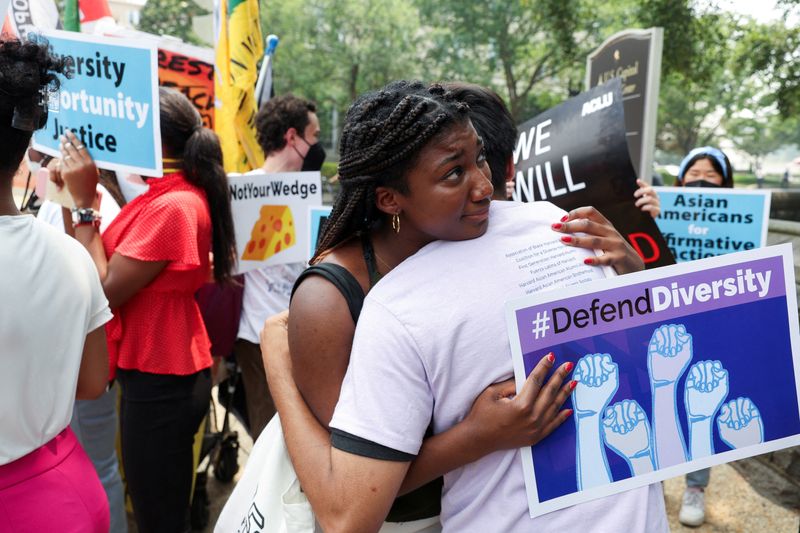 &copy; Reuters. FILE PHOTO: People embrace each other as demonstrators for and against the U.S. Supreme Court decision to strike down race-conscious student admissions programs at Harvard University and the University of North Carolina confront each other, in Washington,