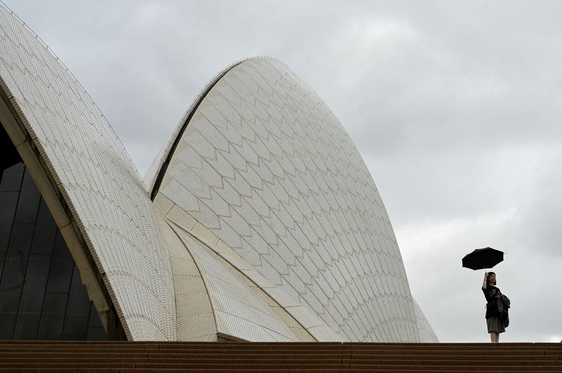 &copy; Reuters. FOTO DE ARCHIVO. Una mujer sostiene un paraguas en la Ópera de Sídney durante un día nublado y lluvioso en Sídney, Australia. 20 de abril de 2023. REUTERS/Jaimi Joy