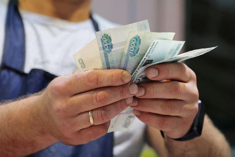 © Reuters. FILE PHOTO: A vendor counts Russian rouble banknotes at a market in Saint Petersburg, Russia July 9, 2023.  REUTERS/Anton Vaganov