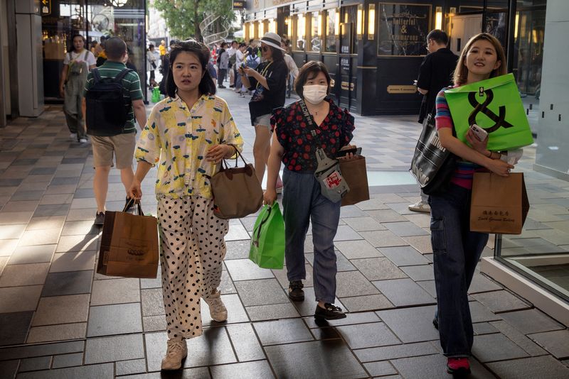 &copy; Reuters. FILE PHOTO: People carry shopping bags in a shopping district in Beijing, China, July 14, 2023. REUTERS/Thomas Peter/File Photo