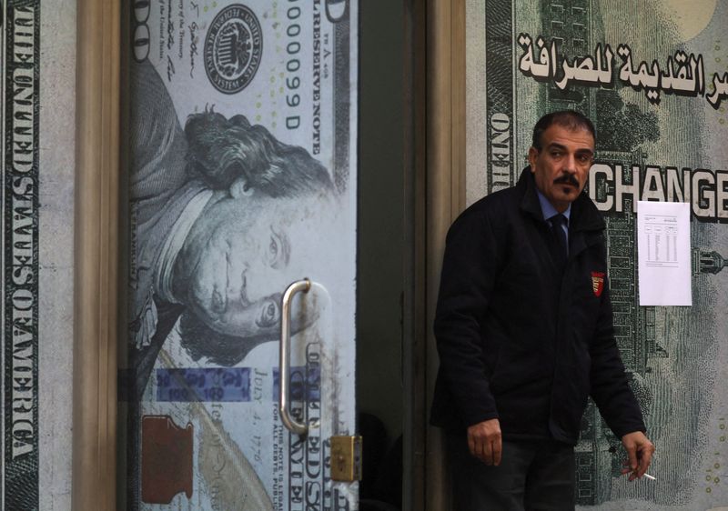 &copy; Reuters. FILE PHOTO: A security man guards in front of a currency exchange bureau advertisement showing image of the U.S. dollar in Cairo, Egypt January 17, 2023. REUTERS/Amr Abdallah Dalsh/File Photo