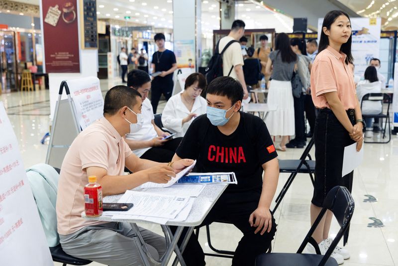 &copy; Reuters. FILE PHOTO: People attend a job fair in a mall in Beijing, China June 30, 2023. REUTERS/Thomas Peter/File Photo