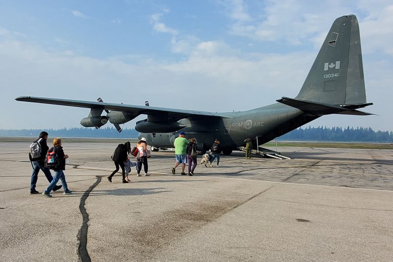 &copy; Reuters. People walk to a Royal Canadian Air Force transport plane while being evacuated from an approaching wildfire in Hay River, Northwest Territories, Canada August 14, 2023.  Canadian Forces/Handout via REUTERS 