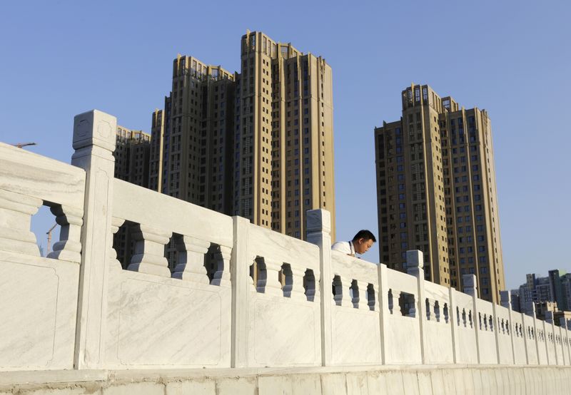 &copy; Reuters. FILE PHOTO: A real estate agent staff member stands on a bridge near new apartment blocks in Beijing's Wangjing area, China, September 18, 2015. REUTERS/Jason Lee/File Photo