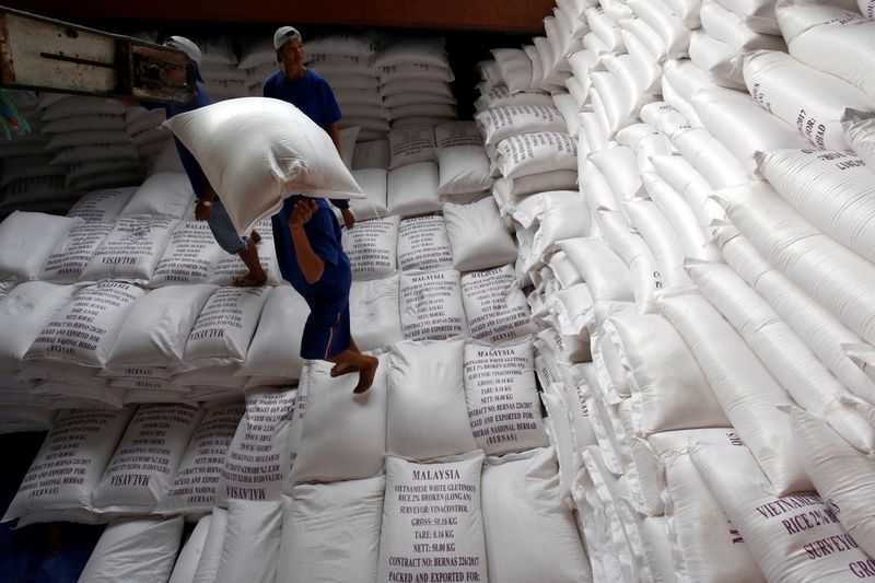 &copy; Reuters. FILE PHOTO: Men load rice bags to a ship for export at a rice processing factory in Vietnam's southern Mekong delta, Vietnam July 6, 2017. REUTERS/Kham/File Photo
