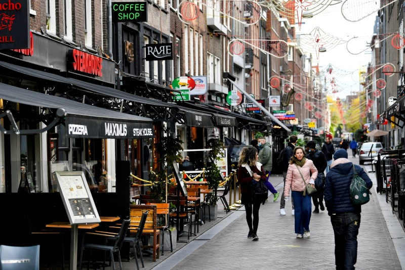 &copy; Reuters. FILE PHOTO: People walk past restaurants and bars in Amsterdam, Netherlands October 14 2020. REUTERS/Piroschka van de Wouw/File Photo