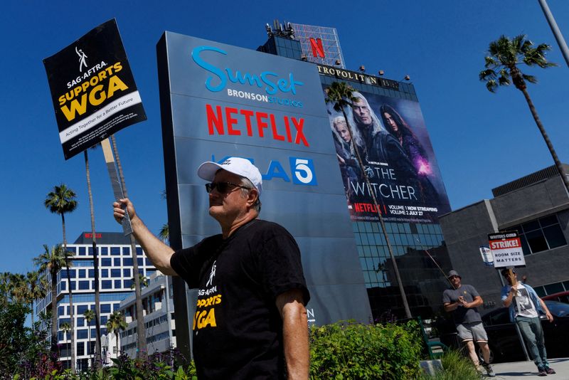 &copy; Reuters. FILE PHOTO: Striking Writers Guild of America (WGA) members walk the picket line in front of Netflix offices in Los Angeles, California, U.S., July 12, 2023.   REUTERS/Mike Blake/File Photo