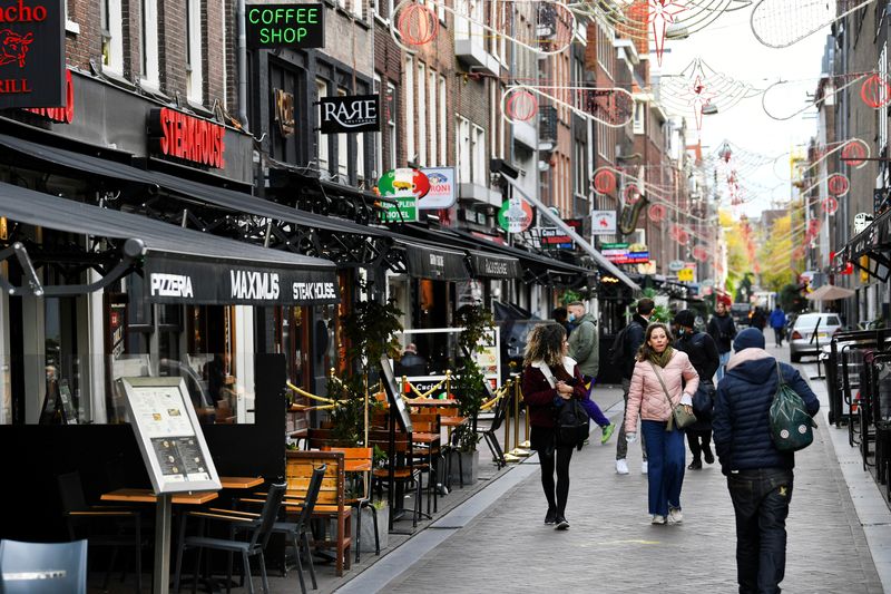 &copy; Reuters. FILE PHOTO: People walk past restaurants and bars following the new social restrictions announced by the Dutch government, as the Netherlands battle to control the spread of the coronavirus disease (COVID-19), in Amsterdam, Netherlands October 14 2020. RE