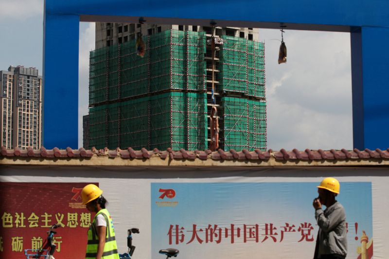 &copy; Reuters. FILE PHOTO: Workers walk past a construction site of residential buildings by property developer Country Garden in Kunming, Yunnan province, China September 17, 2019. REUTERS/Wong Campion/File Photo