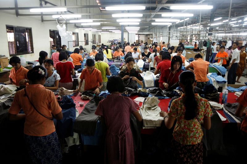 &copy; Reuters. Lavoratori cuciono e sistemano abiti in una fabbrica di abbigliamento nella zona industriale di Hlaing Tar Yar a Yangon. REUTERS/Soe Zeya Tun/File Photo