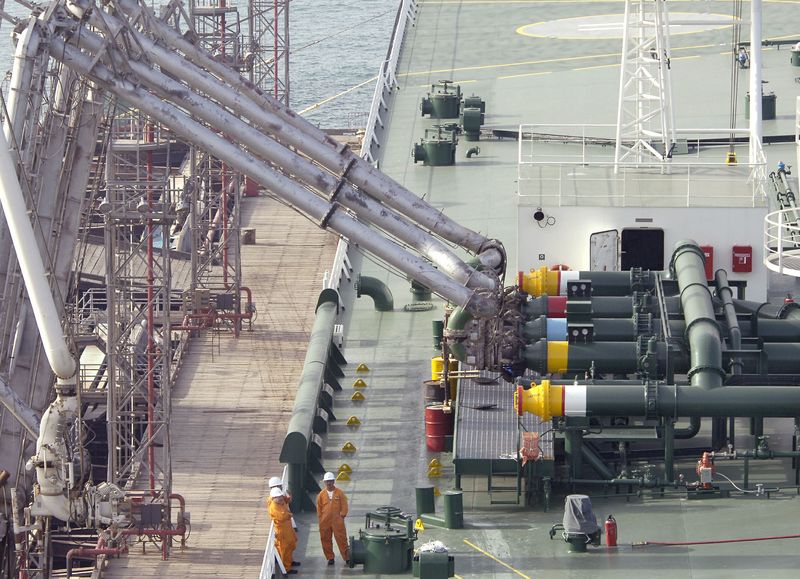 &copy; Reuters. موظفون  يشرفون على تحميل النفط الخام في مصفاة ميناء الأحمدي بالكويت في صورة من أرشيف رويترز.
