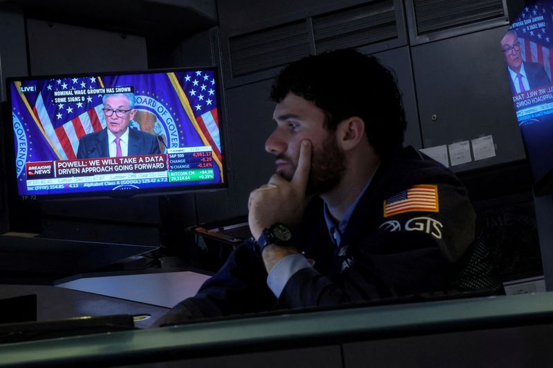 &copy; Reuters. FOTO DE ARCHIVO. Un operador trabaja, mientras una pantalla muestra una conferencia de prensa del presidente de la Junta de la Reserva Federal, Jerome Powell, luego del anuncio de la tasa de interés de la Fed, en el piso de la Bolsa de Valores de Nueva Y