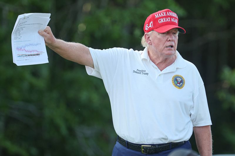 &copy; Reuters. Aug 11, 2023; Bedminster, New Jersey, USA; Former President Donald Trump holds papers showing the projections for the 2024 republican candidate primary polls during the first round of the LIV Golf Bedminster golf tournament at Trump National Bedminster. /