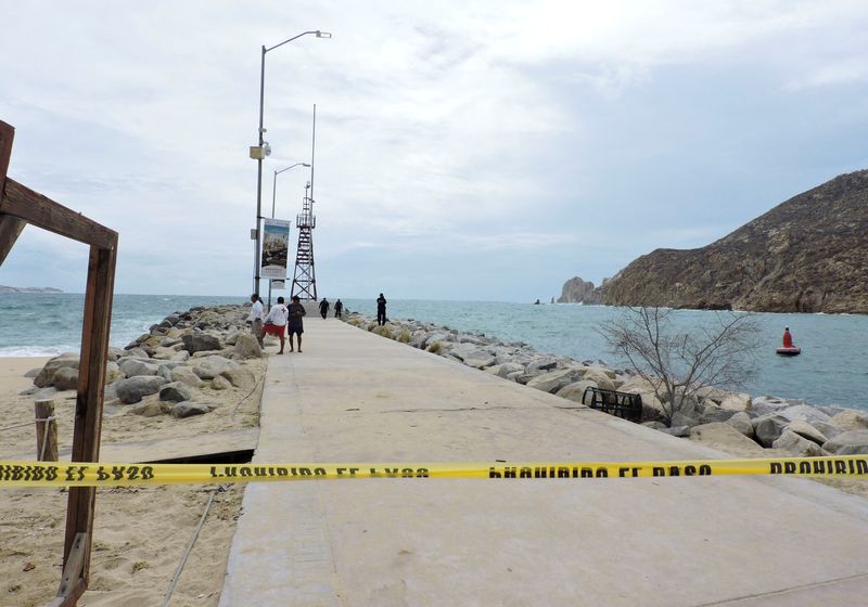 © Reuters. Police officers and lifesavers stand at a breakwater that was closed as a security measure by local authorities while the Category 4 Hurricane Hilary rushes toward Mexico's Baja California peninsula, in Cabo San Lucas, Mexico, August 18, 2023. REUTERS/Monserrat Zavala 