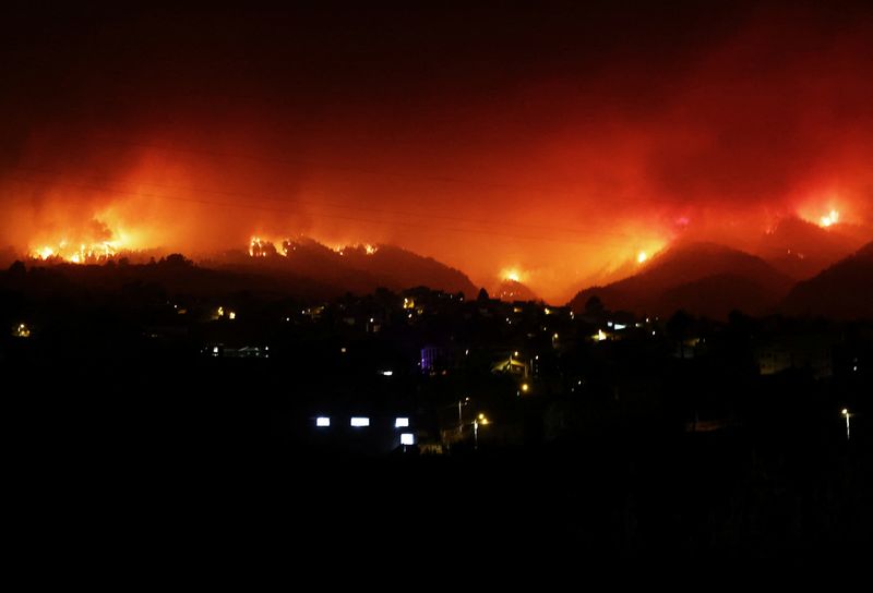 &copy; Reuters. منظر للنيران فوق الجبال في قرية لا فيكتوريا  حيث اندلعت حرائق الغابات خارج نطاق السيطرة في جزيرة تينيريفي بإسبانيا يوم السبت. تصوير: ناشو دو