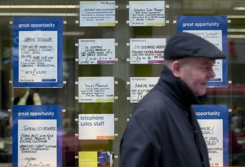 &copy; Reuters. A man walks past job advertisements in the window of a recruitment office in central London February 19, 2014. REUTERS/Neil Hall/File photo