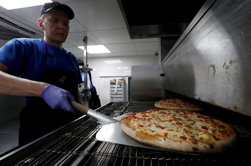 &copy; Reuters. FILE PHOTO: A staff member prepares pizzas at a Domino's Pizza restaurant in Moscow, Russia, July 14, 2017. REUTERS/Sergei Karpukhin/File Photo