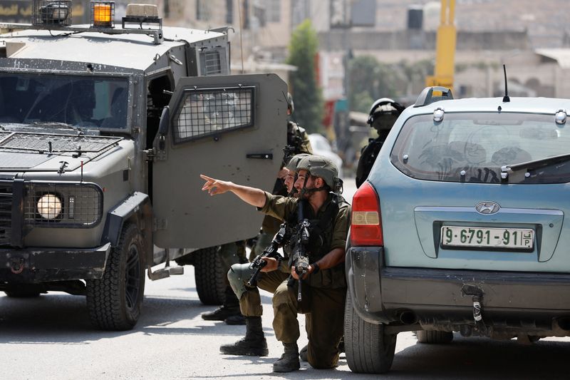 © Reuters. جنود إسرائيليون عند موقع حادث إطلاق نار بالقرب من مدينة الخليل في الضفة الغربية المحتلة يوم الاثنين. تصوير: موسى قواسمة - رويترز.