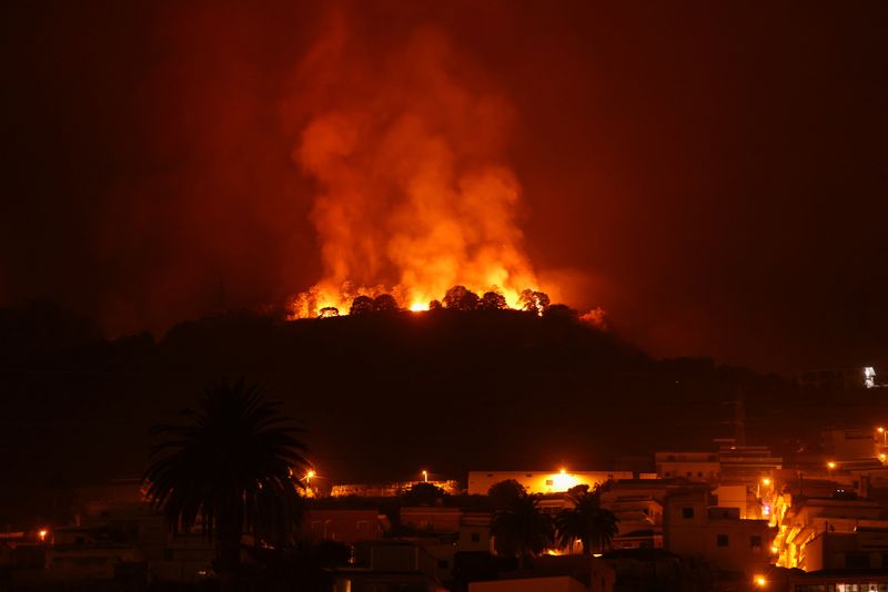 &copy; Reuters. منظر لحريق فوق جبال بالقرب من منازل خاوية بعد عمليات إجلاء في قرى مختلفة في الشمال إذ تخرج حرائق غابات عن السيطرة في جزيرة تينيريفي بجزر الك