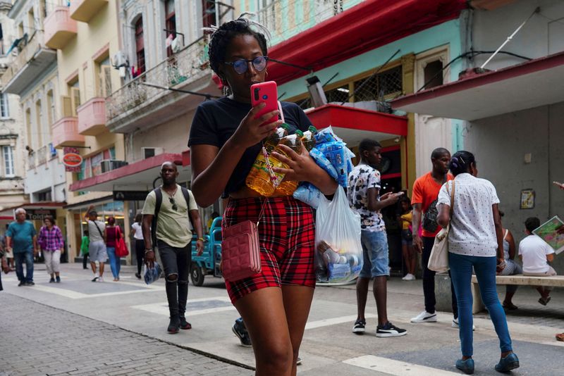 &copy; Reuters. A woman carries goods at a commercial street in Havana, Cuba, August 16, 2023. REUTERS/Alexandre Meneghini