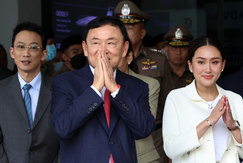 &copy; Reuters. Former Thai Prime Minister Thaksin Shinawatra, who is expected to be arrested upon his return as he ends almost two decades of self-imposed exile, gestures while flanked by his son Panthongtae Shinawatra and daughter Paetongtarn Shinawatra at Don Mueang a