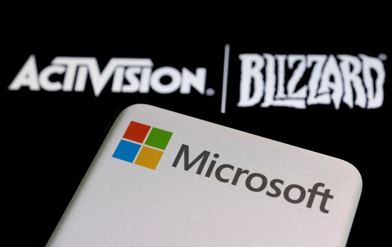&copy; Reuters.  Il logo Microsoft è visibile su uno smartphone posizionato sul logo Activision Blizzard visualizzato in questa illustrazione scattata il 18 gennaio 2022.