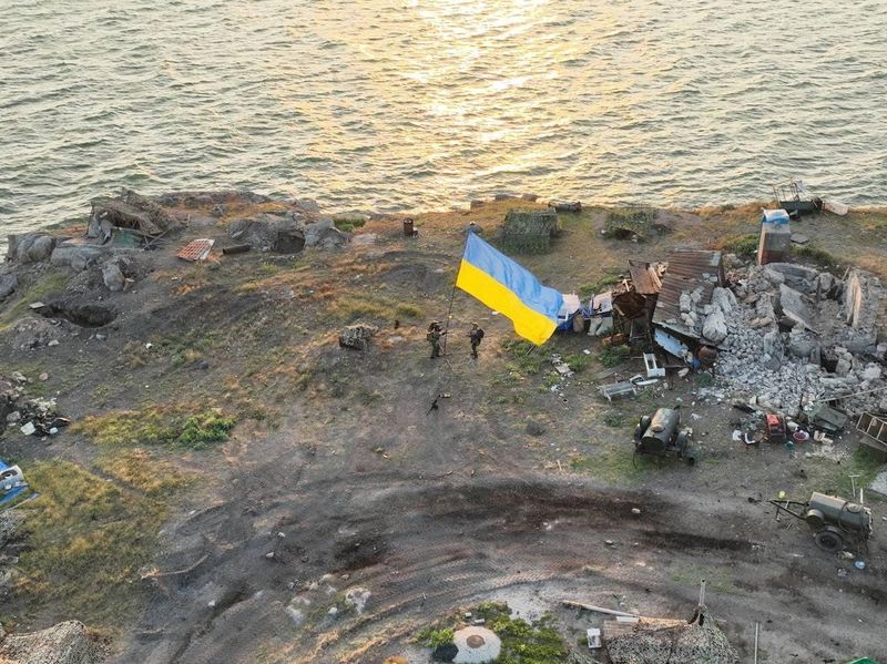 &copy; Reuters. جنود أوكرانيون يرفعون علم بلادهم في جزيرة الثعبان بمنطقة أوديسا. الصورة من أرشيف رويترز.