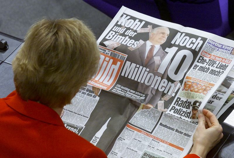 &copy; Reuters. FILE PHOTO: An unidentified Christian Democratic (CDU) member of the Bundestag lower house of parliament reads the front page of Germany's biggest daily newspaper "Bild" ahead of a parliamentary debate in the Reichstag in Berlin./File Photo