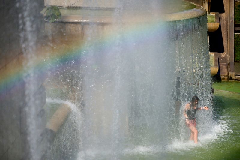 &copy; Reuters. Une femme se rafraîchit dans les fontaines du Trocadéro près de la Tour Eiffel à Paris, alors qu'une vague de chaleur frappe la France. /Photo prise le 3 août 2022/REUTERS/Sarah Meyssonnier