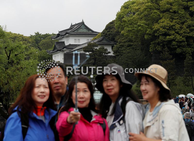 &copy; Reuters. FILE PHOTO: Chinese tourists take photos in front of the Imperial Palace in Tokyo, Japan, April 30, 2019. REUTERS/Kim Kyung-Hoon/File Photo