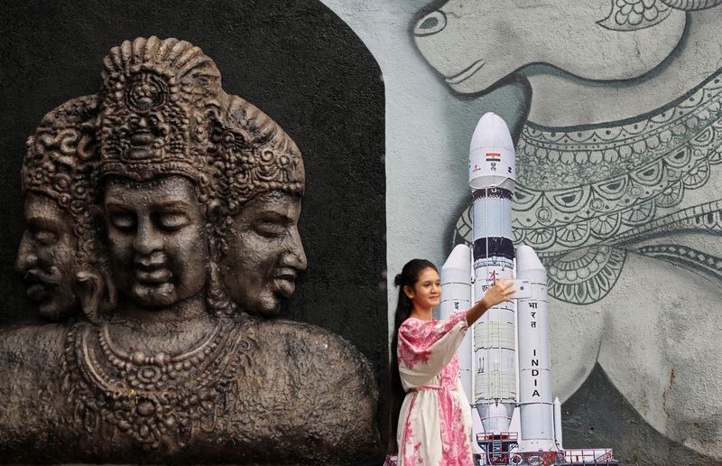 &copy; Reuters. Una giovane donna si scatta un selfie con un modellino del veicolo di lancio Chandrayaan 3 Mark-III fuori da un tempio a Mumbai, in India, 14 luglio 2023. REUTERS/Francis Mascarenhas/File Photo