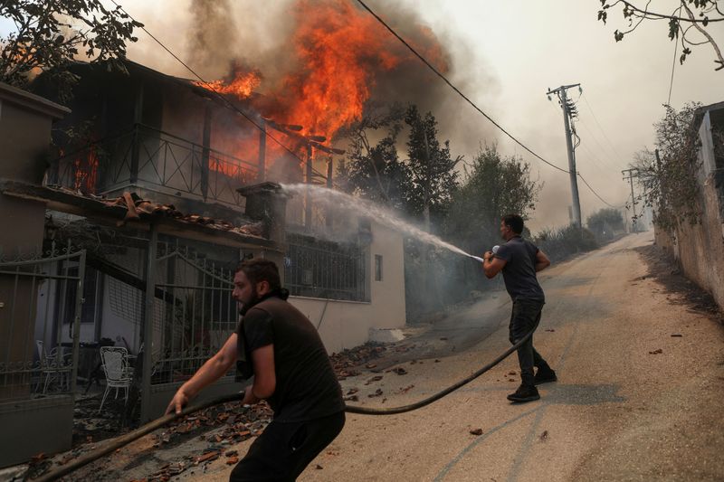 &copy; Reuters. Incêndio florestal atinge moradia em Menidi, cidade próxima a Atenas, na Grécia
23/08/2023
REUTERS/Elias Marcou