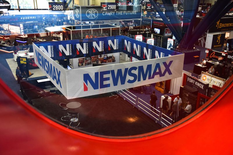 &copy; Reuters. A Newsmax booth broadcasts as attendees try out the guns on display at the National Rifle Association (NRA) annual convention in Houston, Texas, U.S. May 29, 2022. Picture taken through glass. REUTERS/Callaghan O'Hare/File Photo