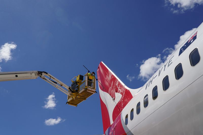 &copy; Reuters. An aircraft appearance crew member cleans an aircraft as Qantas begins preparing and equipping planes for the return of international flights, in anticipation of Australia easing coronavirus disease (COVID-19) border regulations, at Sydney Airport in Sydn