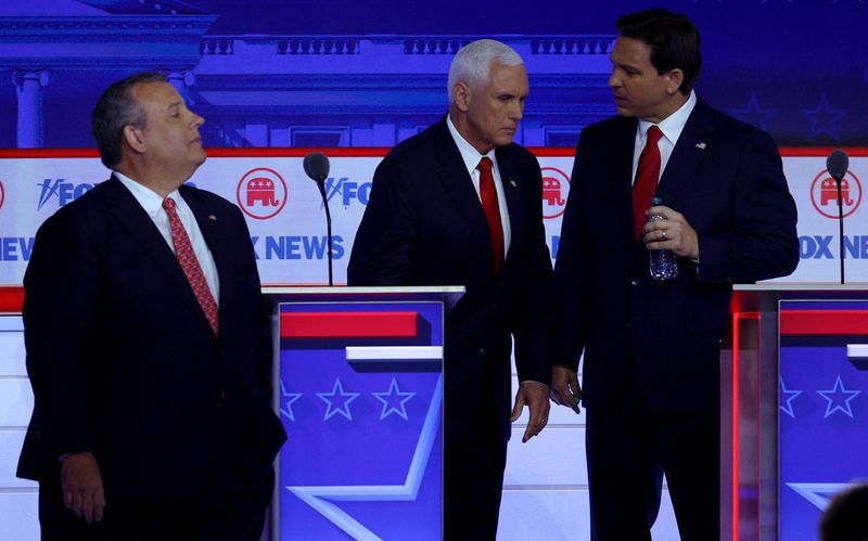 &copy; Reuters. Former New Jersey Governor Chris Christie walks past as former U.S. Vice President Mike Pence talks with Florida Governor Ron DeSantis during a commercial break at the first Republican candidates' debate of the 2024 U.S. presidential campaign in Milwaukee