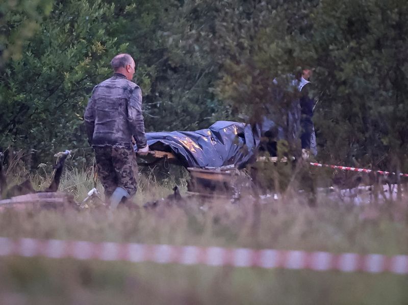 &copy; Reuters. Especialistas en emergencias transportan una bolsa para cadáveres cerca de los restos del avión privado vinculado al jefe de los mercenarios de Wagner, Yevgeny Prigozhin, en el lugar del accidente, en el óblast de Tver, Rusia. 24 de agosto de 2023. REU