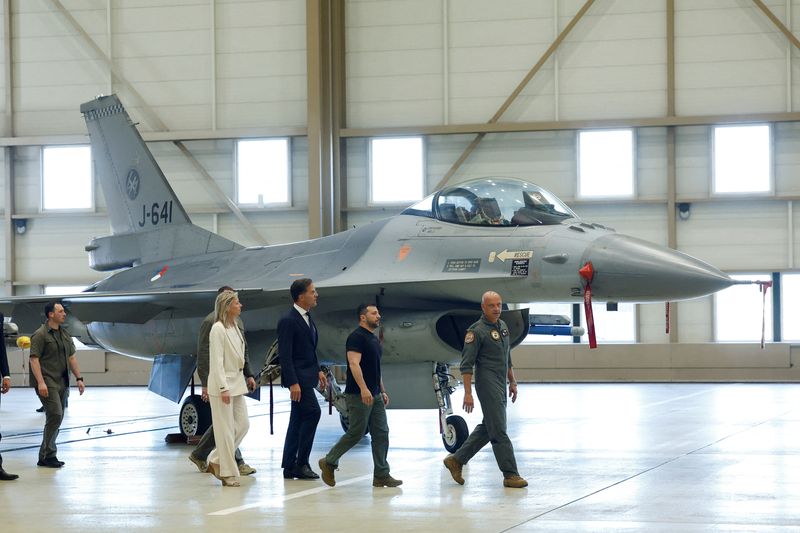 &copy; Reuters. Photo d'archives du président ukrainien Volodymyr Zelensky et le Premier ministre néerlandais Mark Rutte qui passent devant un avion de chasse F-16. /Photo prise le 20 août 2023 à Eindhoven, Pays-Bas/REUTERS/Piroschka van de Wouw