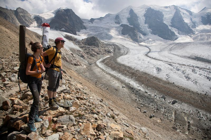 &copy; Reuters. FILE PHOTO: Glaciologist Andreas Linsbauer and assistant Andrea Millhaeusler stand on a border moraine of the Pers Glacier near the Alpine resort of Pontresina, Switzerland July 21, 2022.  REUTERS/Arnd Wiegmann/File Photo